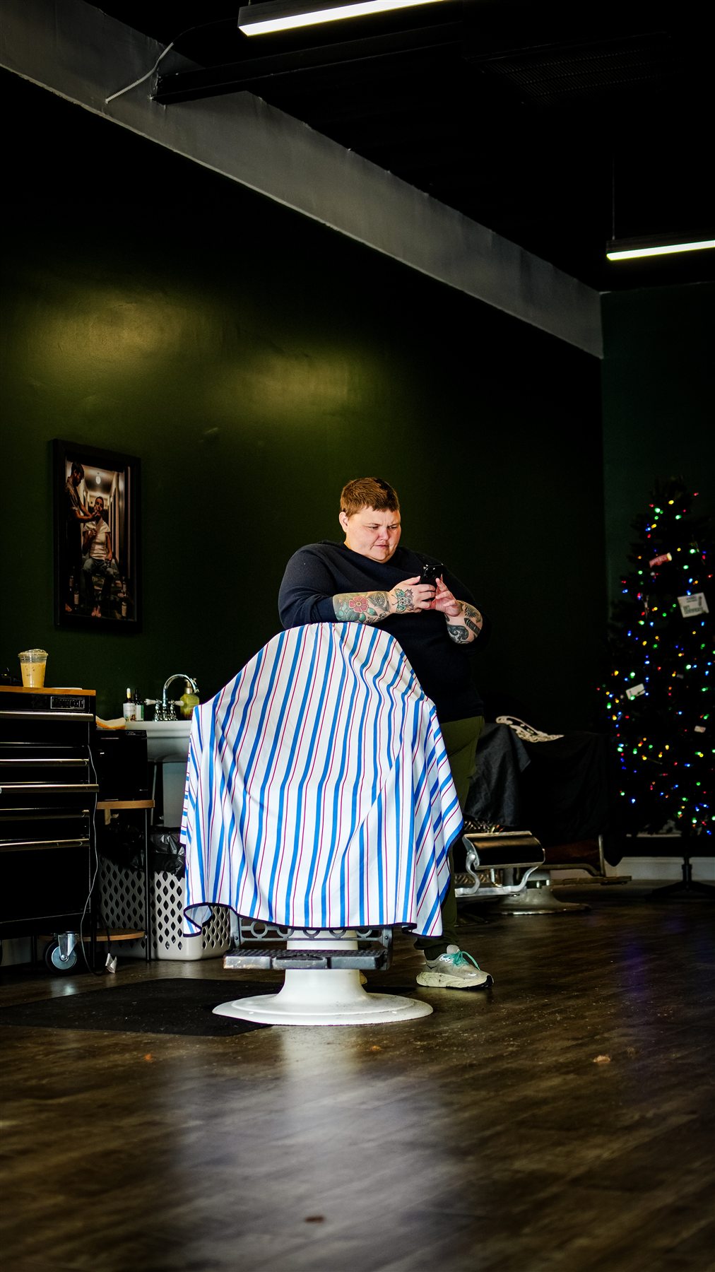 A barber cleaning and checking her clippers at a tidy workstation